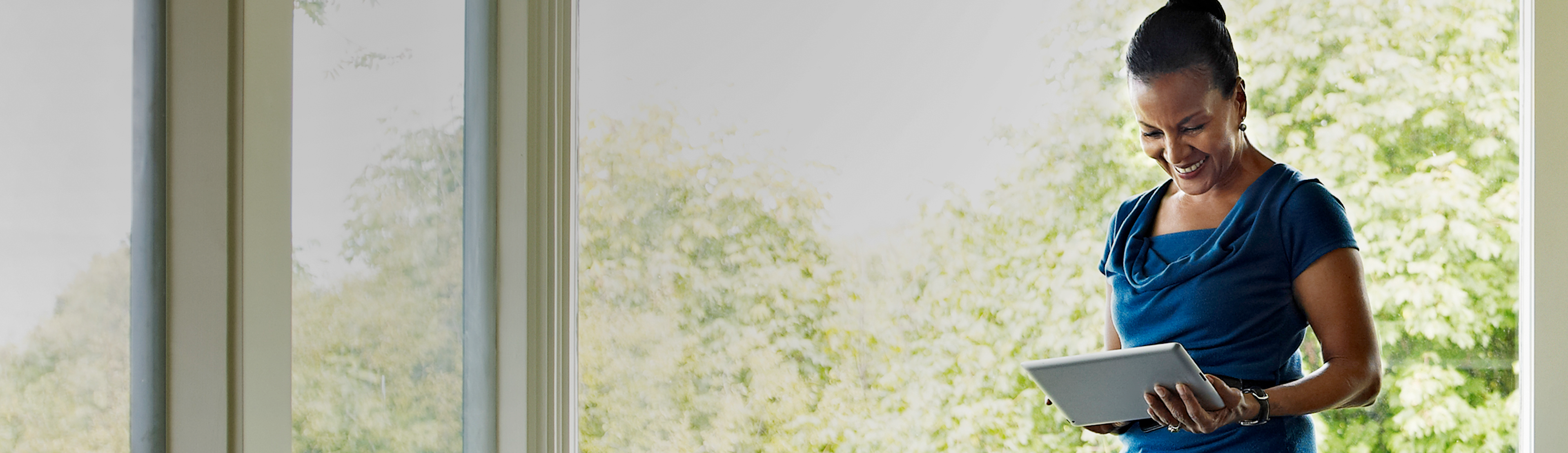 Person smiling while watching content on tablet.