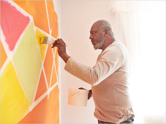 Person painting colorful wall.