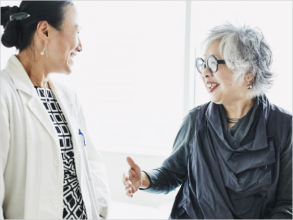 Physician and patient smiling in conversation.