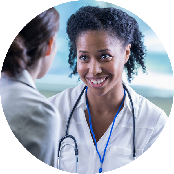 Attentive mid adult female doctor sits across from an unrecognizable new patient as she counsels her at work.