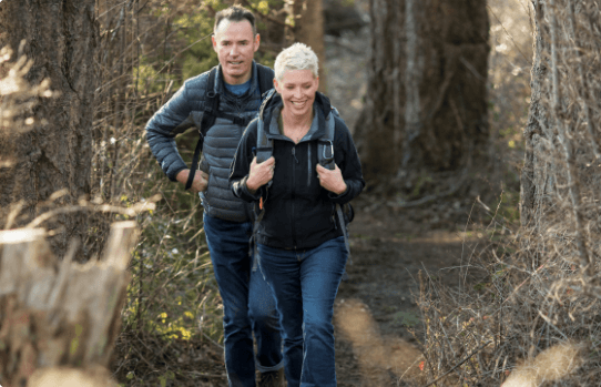 Husband and wife hiking in the woods.