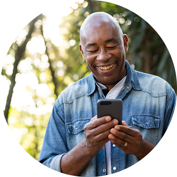 Middle-aged Black man smiles while using mobile phone app.