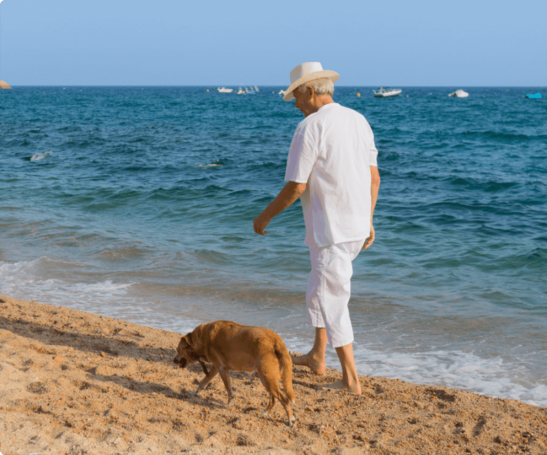 Spinal Cord Stimulation patient Paul walking his dog on the beach.