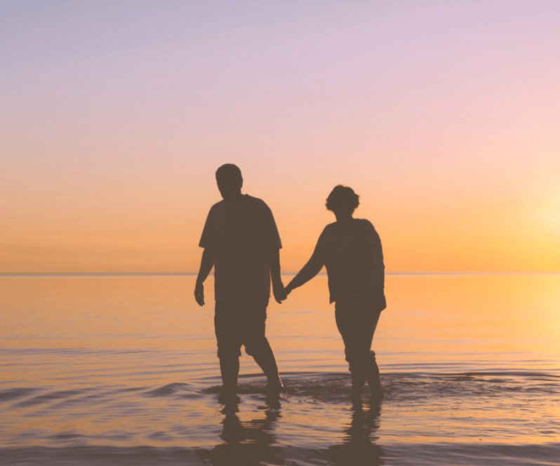 Spinal Cord Stimulation patient Judith walking on the beach at sunset.