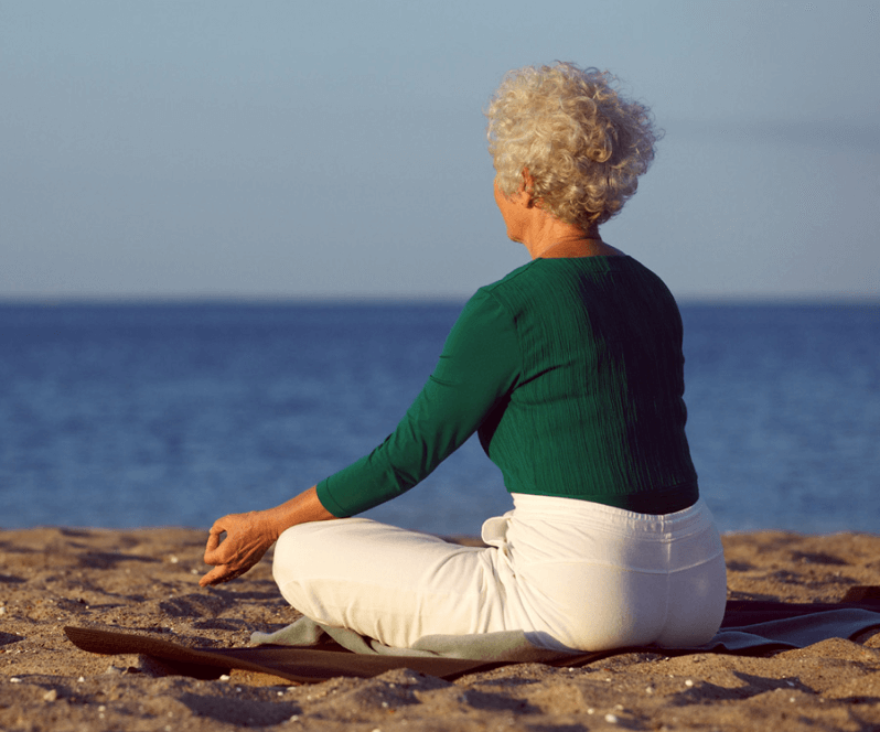 Spinal Cord Stimulation patient Hellen doing yoga on the beach.