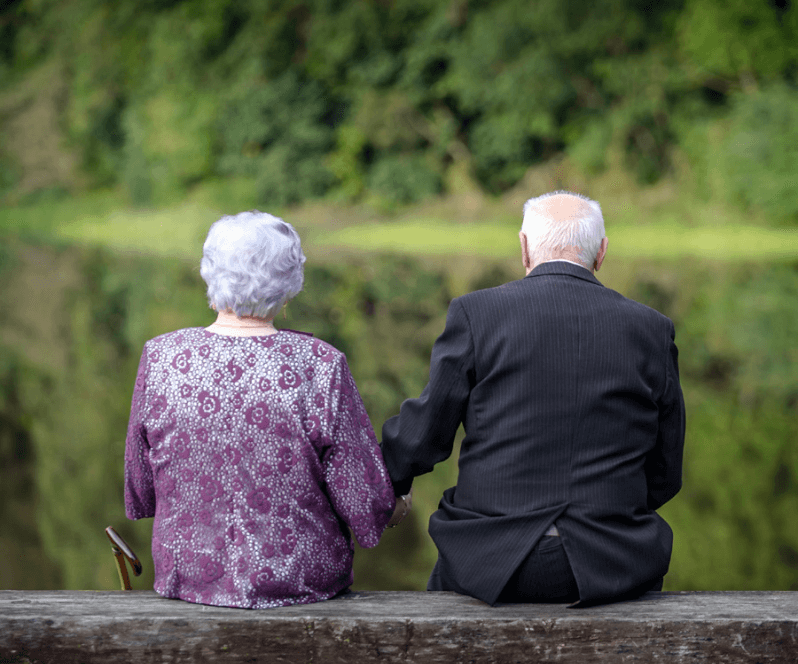 Vertiflex Procedure patient Mary sitting on a bench with her husband.