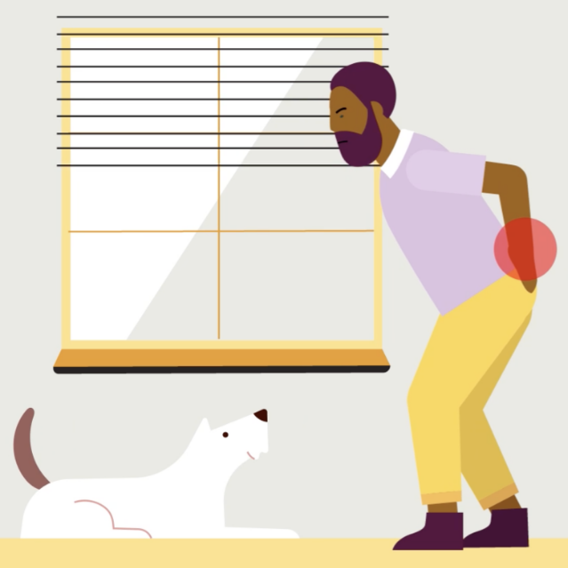 Man with back pain tries to pet dog on the floor.