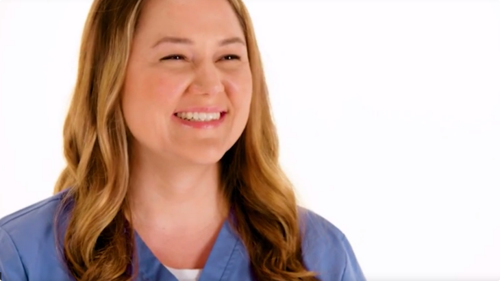 Woman in blue scrubs smiling.