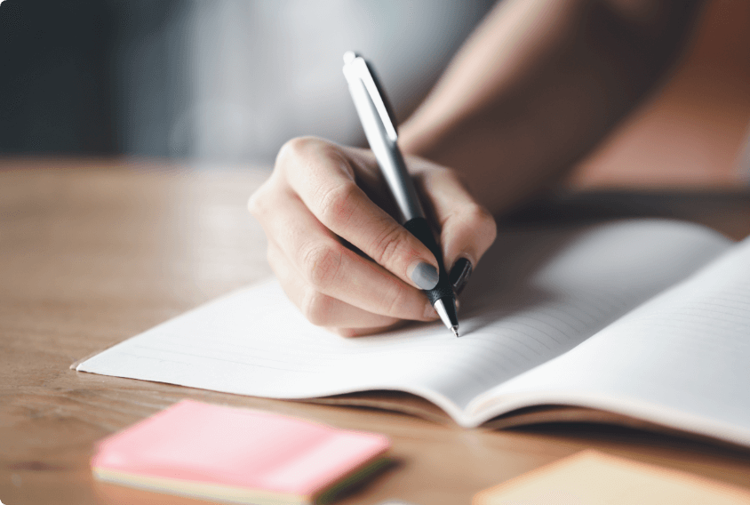 A woman writing in a notebook.