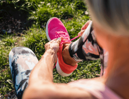 A woman tying her shoes.