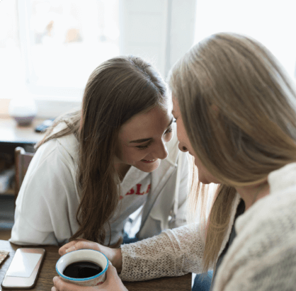 Two women sitting at a table talking.