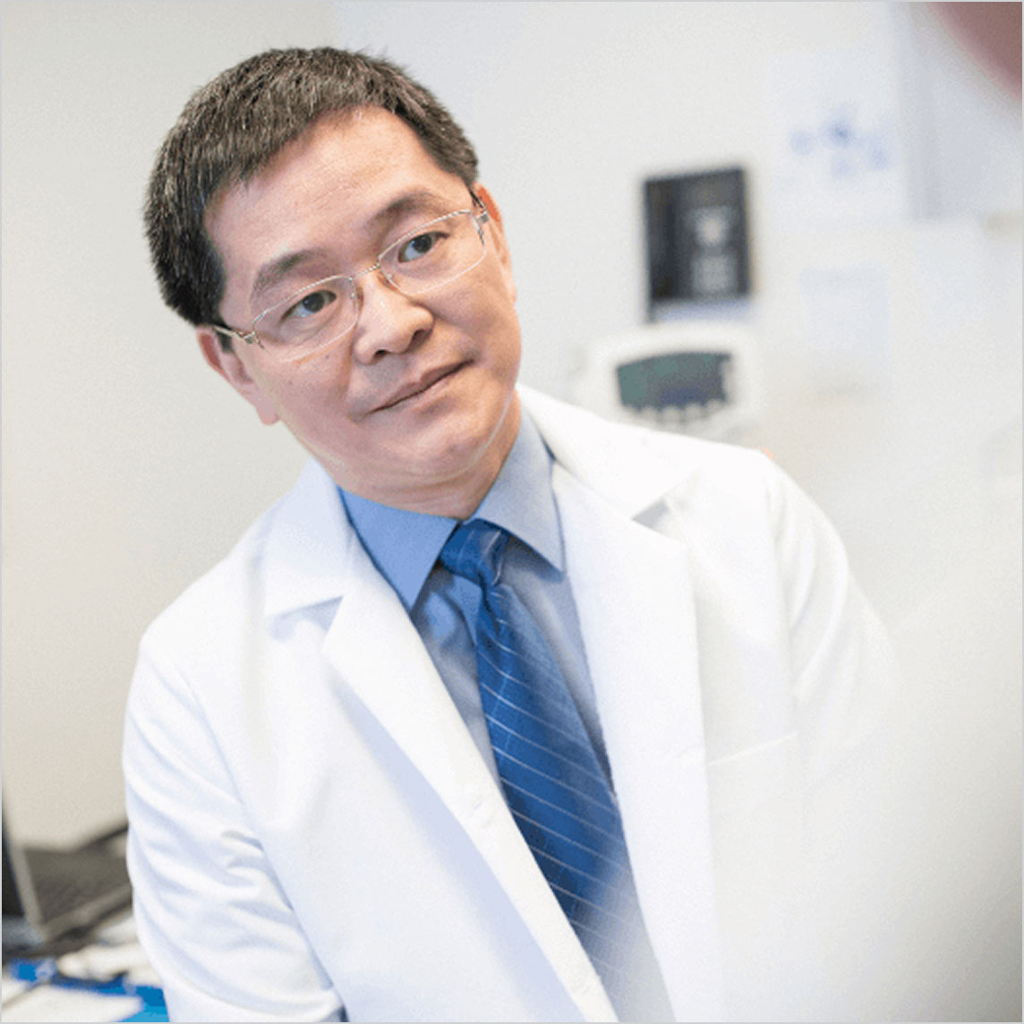 A healthcare provider in a white coat listens attentively in a medical office.